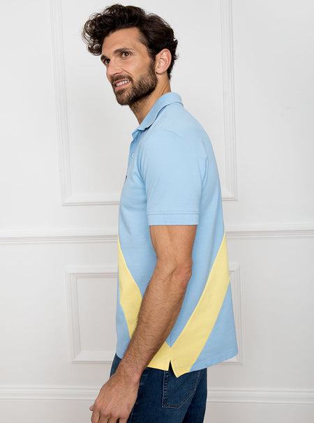 Man wearing sky blue 100% cotton polo shirt with lemon yellow sash detail and Newmarket 875 horse logo embroidered on the front.
